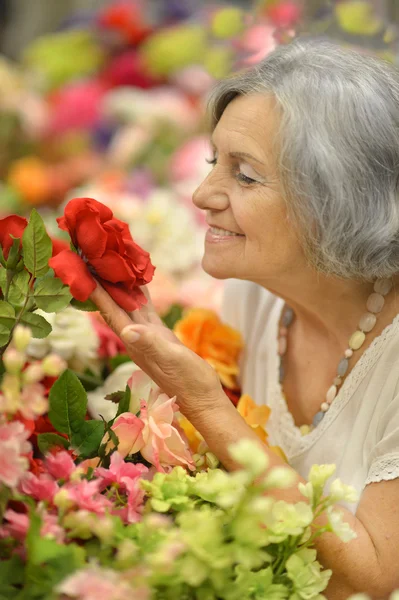 Mujer mayor con flores — Foto de Stock