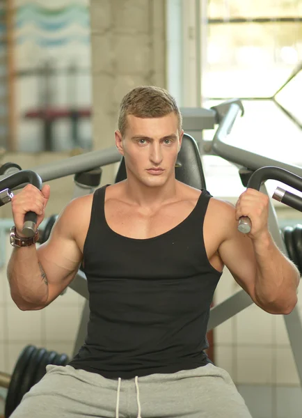 Jeune homme exercices dans la salle de gym — Photo