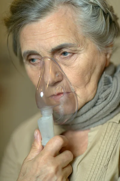 Больная пожилая женщина с ингалятором — стоковое фото
