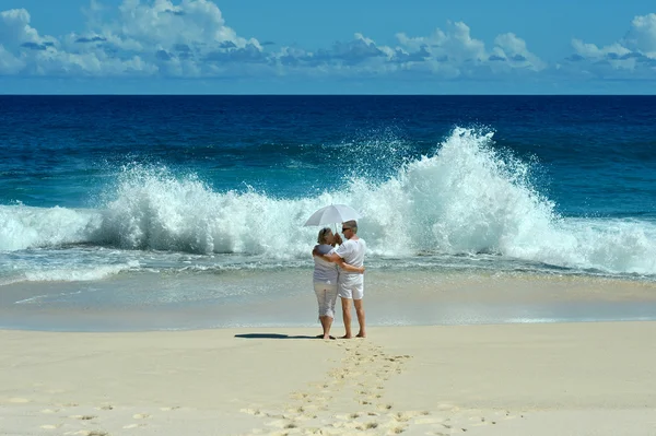 Deniz kıyısı yürüyen yaşlı çift — Stok fotoğraf