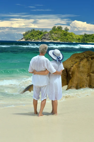 Coppia anziana in piedi sulla spiaggia — Foto Stock