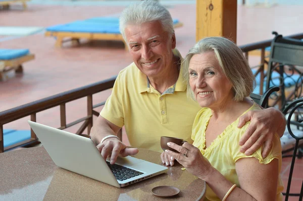 Äldre par sitter med laptop — Stockfoto