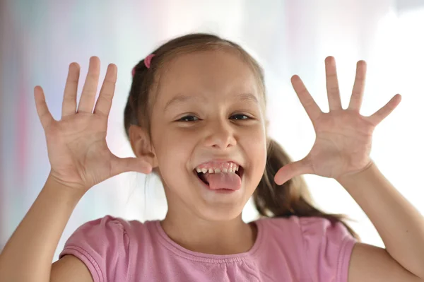 Маленькая девочка с высунутым языком — стоковое фото