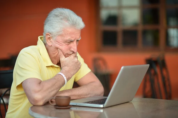 Starszy mężczyzna siedzi z laptopa — Zdjęcie stockowe