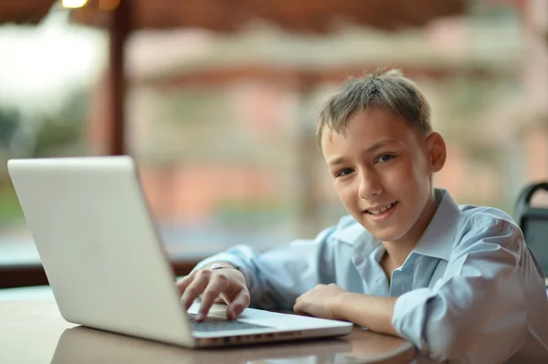 Chłopiec z laptopa na stole — Zdjęcie stockowe