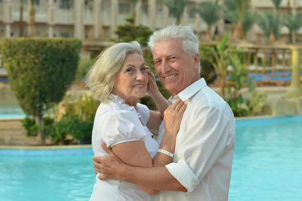 Senior couple relaxing near pool — Stock Photo, Image