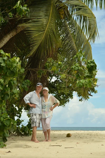 Älteres Paar geht am Strand spazieren — Stockfoto