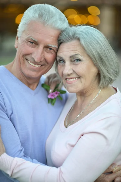 Sonriente pareja de ancianos con flores — Foto de Stock