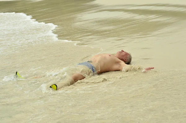 Homem idoso deitado na praia — Fotografia de Stock