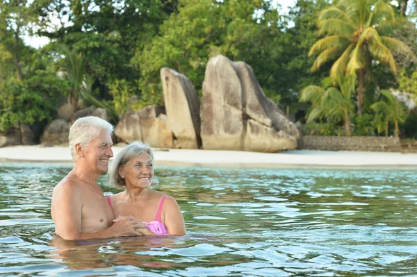 Elderly couple rest at tropical beach — Stock Photo, Image