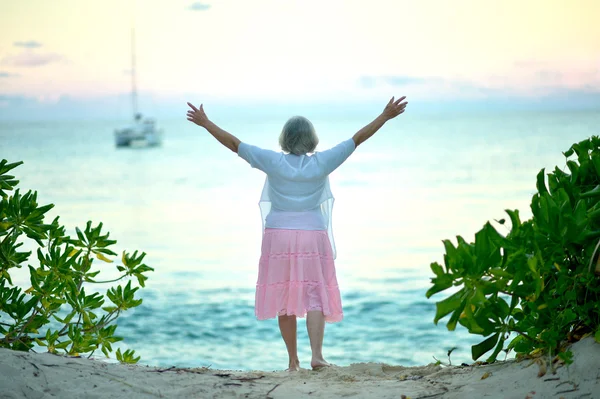 Donna anziana sulla spiaggia — Foto Stock