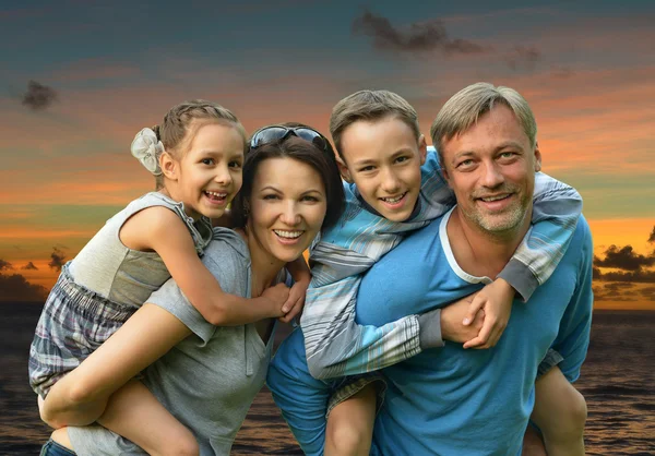 Família na praia do mar ao pôr do sol — Fotografia de Stock