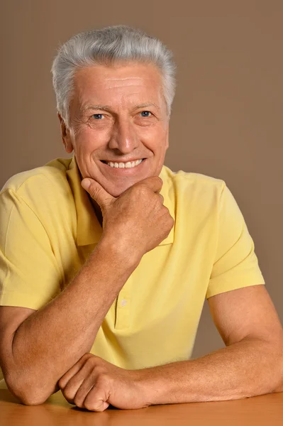 Gondolkodó idősebb férfi mosolyogva — Stock Fotó