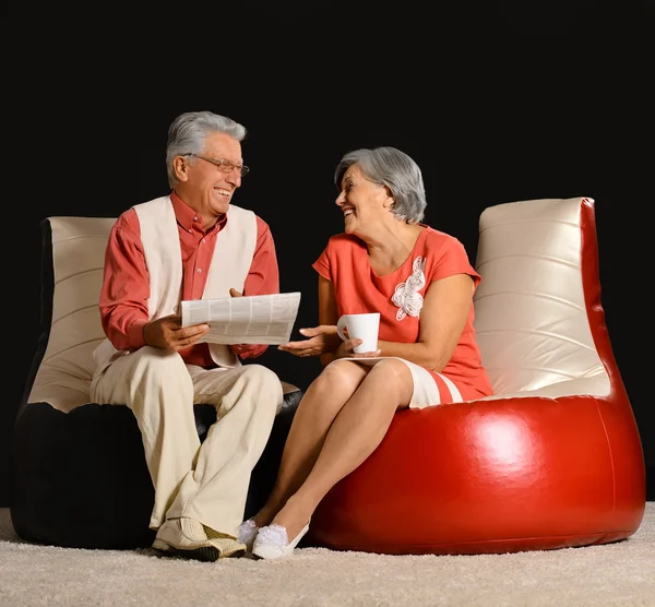 Elderly couple reading newspaper — Stock Photo, Image