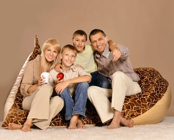 Family sitting on  armchair with tea — Stock Photo, Image