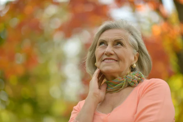 Oudere vrouw in herfstpark — Stockfoto