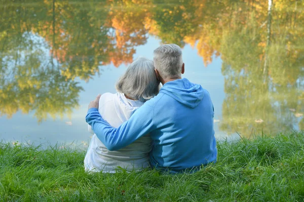 Couple âgé assis près du lac — Photo