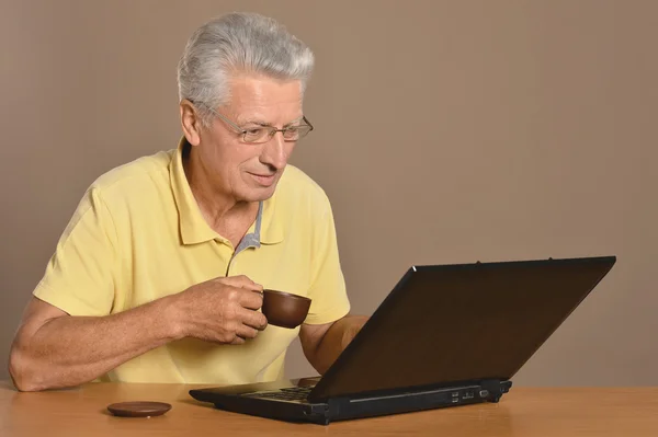 Uomo anziano seduto con computer portatile — Foto Stock