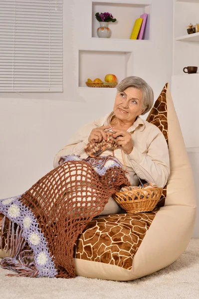 Elderly woman sitting with knitting — Stock Photo, Image