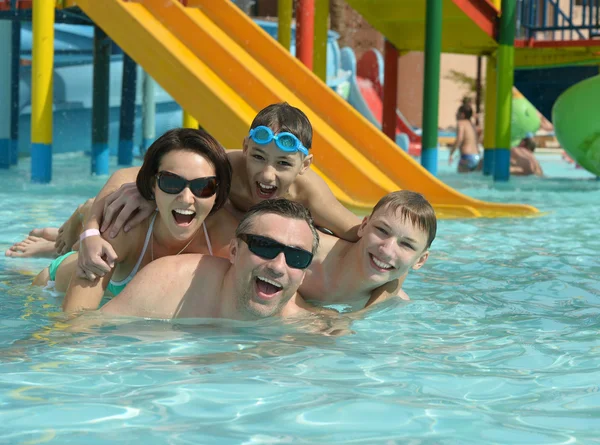 Familia feliz teniendo en la piscina — Foto de Stock