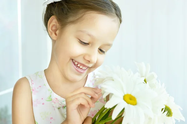 Liten flicka med dasies blommor — Stockfoto