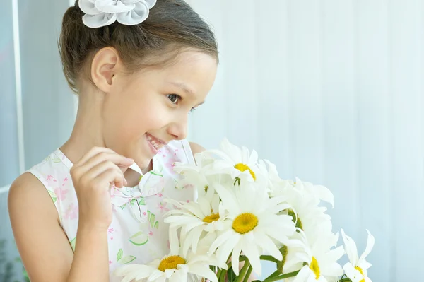 Liten flicka med dasies blommor — Stockfoto