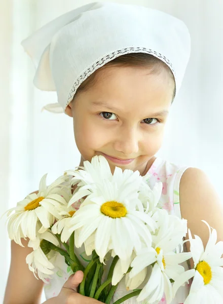 Liten flicka med dasies blommor — Stockfoto