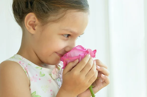 Liten flicka med rosa blomma. — Stockfoto