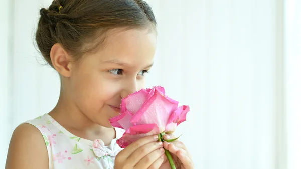 Liten flicka med rosa blomma. — Stockfoto