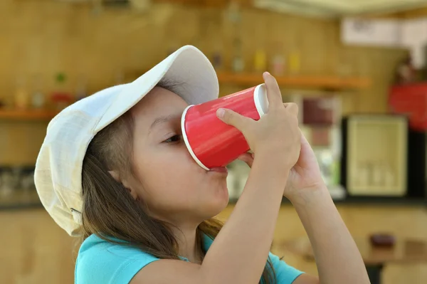 Bebida menina pequena de copo — Fotografia de Stock