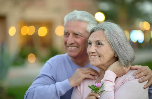 Sourire vieux couple avec des fleurs — Photo