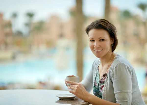 Mujer tomando café cerca de la piscina —  Fotos de Stock