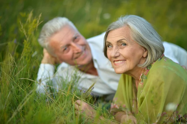 Seniorenpaar liegt im Gras — Stockfoto