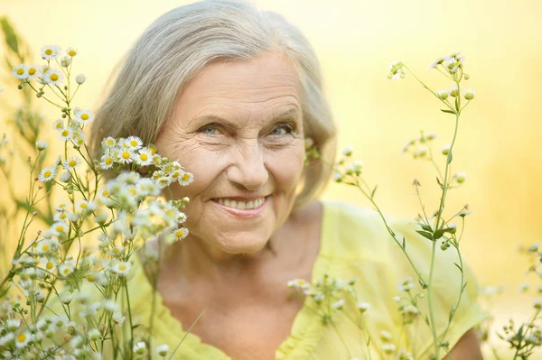 Senior vrouw met bloemen — Stockfoto