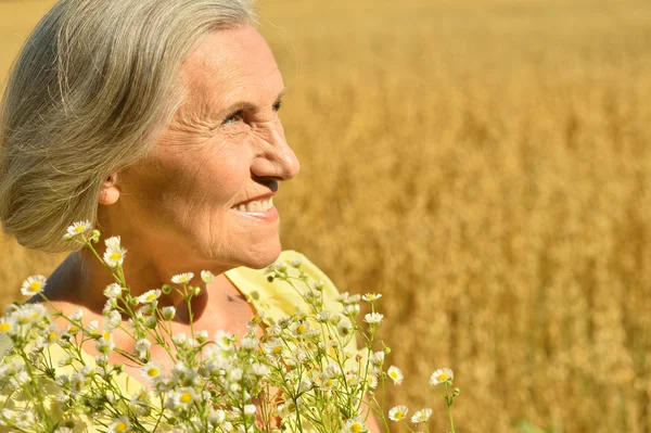 Mujer mayor con flores — Foto de Stock