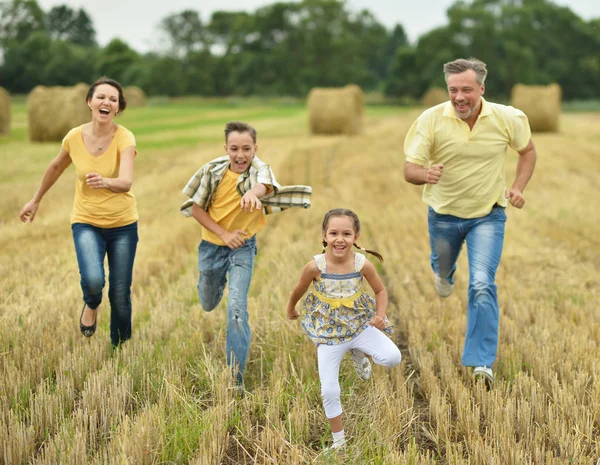 Família feliz no campo de trigo — Fotografia de Stock