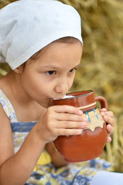 Bambina con latte in campo — Foto Stock