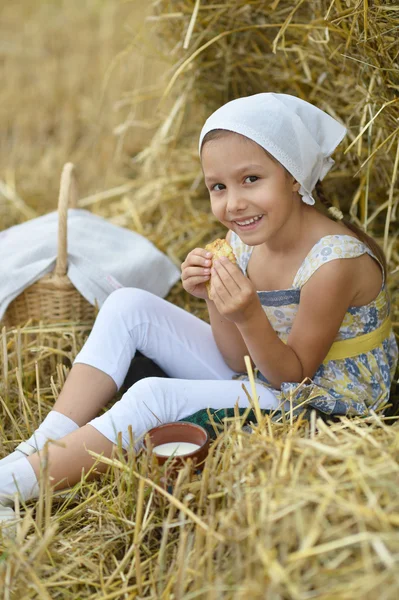 Mädchen mit Milch und Krapfen im Feld — Stockfoto