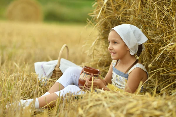 Kleines Mädchen mit Milch im Feld — Stockfoto