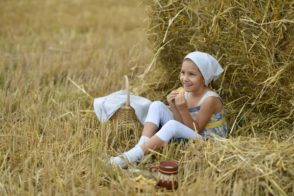 Fille avec du lait et beignet dans le champ — Photo