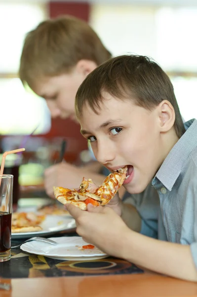 Два мальчика едят пиццу — стоковое фото