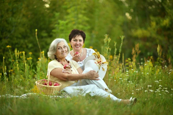 Oudere vrouwen rusten op gras — Stockfoto