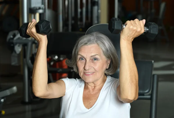 Elderly woman exercising in gym — Stock Photo, Image