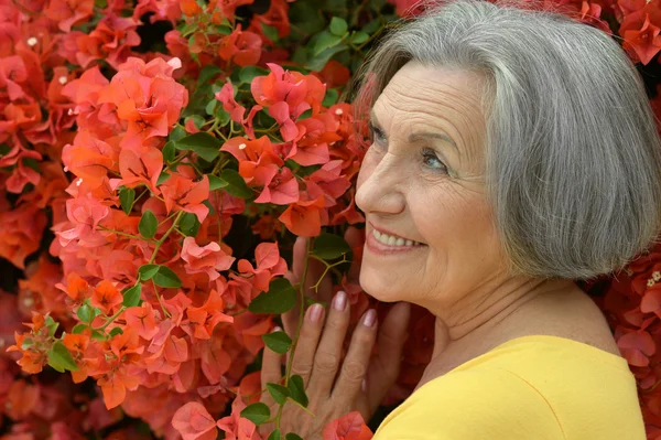 Oudere vrouw met bloemen — Stockfoto