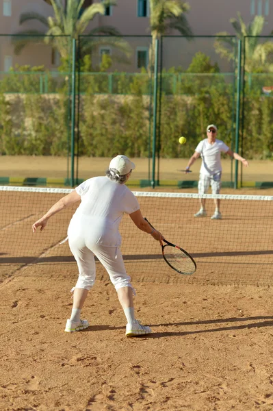 Старшая пара на теннисном корте — стоковое фото