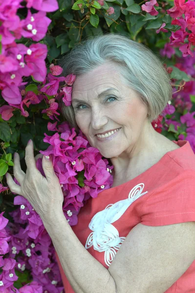 Mujer mayor con flores — Foto de Stock