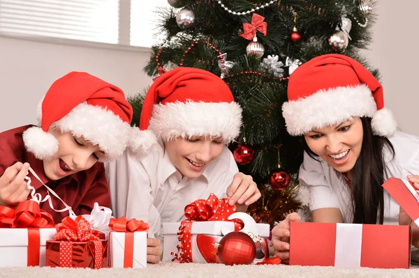 Moeder en kinderen in santa hoeden — Stockfoto