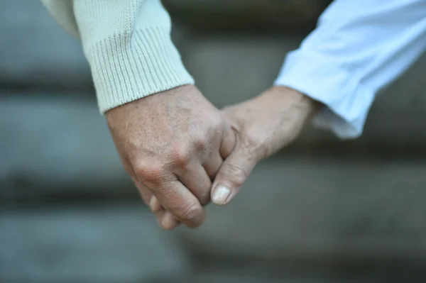 Elderly couple holding hands — Stock Photo, Image