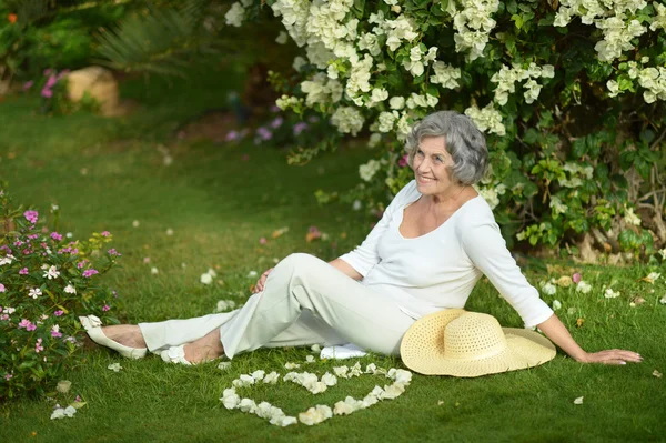 Äldre kvinna med blommor — Stockfoto