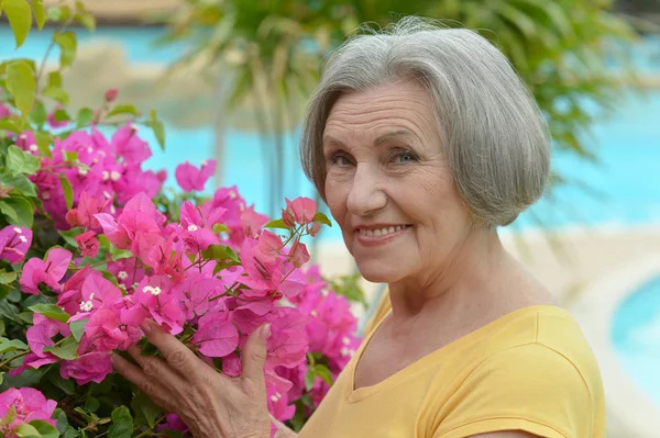 Older woman with flowers — Stock Photo, Image